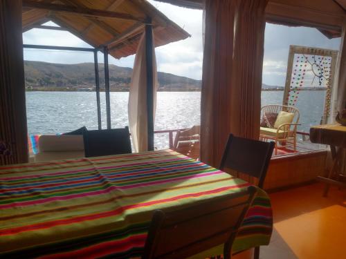 a table on a boat with a view of the water at Uros Titicaca Mallku lodge in Puno