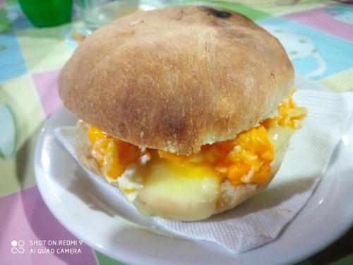 un panino con le uova su un piatto con un rotolo di HOSTAL FAMILIAR a Chillán