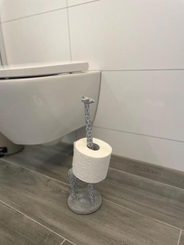 a toilet paper holder with a giraffe standing next to it at Jimmy's Place - Hotelgefühl, Tolle Lage, Terrasse, BBQ in Bad Zwischenahn