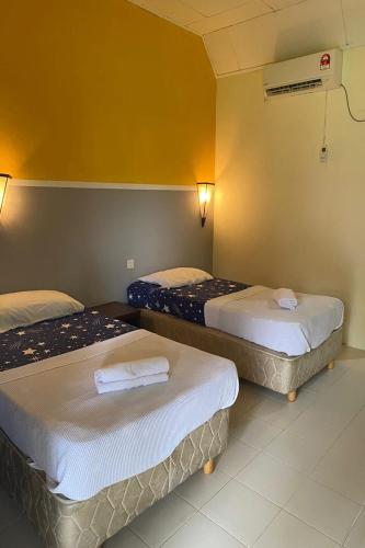 a hotel room with two beds and a fan at Corrie Chalet Pantai Cenang Langkawi in Pantai Cenang