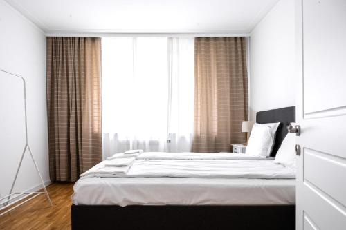 een slaapkamer met een bed en een groot raam bij Contemporary Comfort: 1BD Flat in Lozenetz, Sofia in Sofia