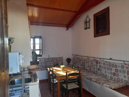 una sala da pranzo con tavolo e divano di Casa El Castillo a Teba