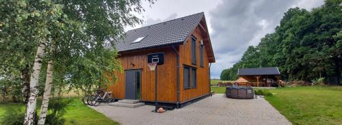 een klein houten huis met een basketbalring bij Pauza Drzewoszewo - Dom nad jeziorem 