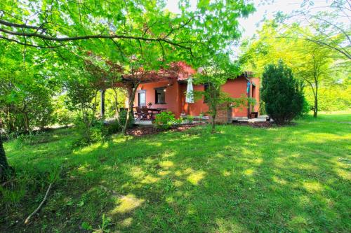 una pequeña casa roja en un patio con árboles en Cabaña El Planto, en Torrelavega