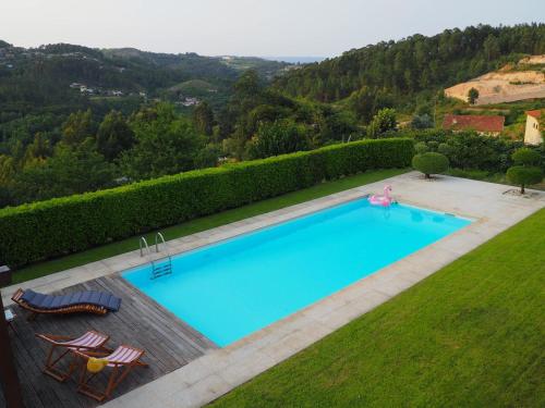 una vista sul soffitto di una piscina con due sedie a sdraio di Casa Travessa do Monte by LovelyStay a Celorico de Basto