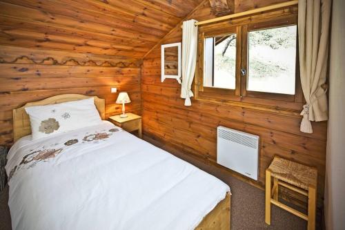 a bedroom with a bed in a log cabin at Meribel Les Allues Ski Chalet with beautiful views in Les Allues