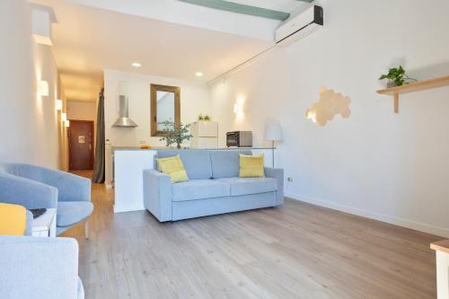 sala de estar con sofá azul y cocina en Citytrip Barceloneta Beach, en Barcelona