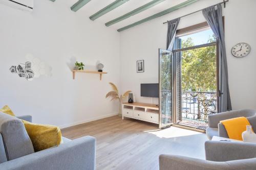 a living room with a couch and a tv and a window at Citytrip Barceloneta Beach in Barcelona