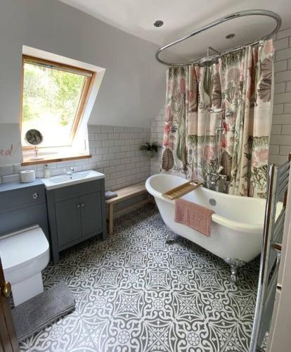 a bathroom with a tub and a toilet and a sink at Middle Lodge in Aberfeldy