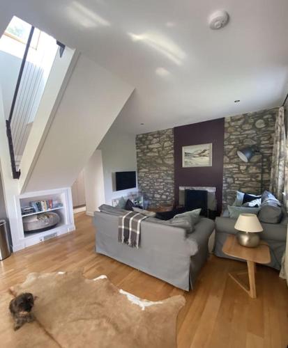 a living room with a couch and a stone wall at Middle Lodge in Aberfeldy