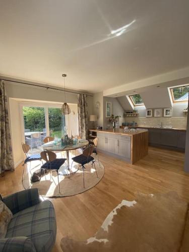 a living room with a table and a kitchen at Middle Lodge in Aberfeldy