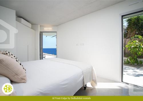 een slaapkamer met een bed en uitzicht op de oceaan bij Al Vent by Solhabitat rentals in Calpe