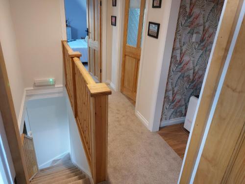 a hallway with a wooden staircase with a wooden hand rail at southview in Portskerra