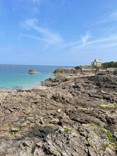 une rive rocheuse avec une maison dans l'océan dans l'établissement Maison Saint-Malo à 1 minute à pied de la plage, à Saint-Malo