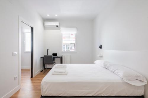 Habitación blanca con cama y escritorio en 1 bedroom 1 bathroom furnished - Salamanca - modern - MintyStay, en Madrid
