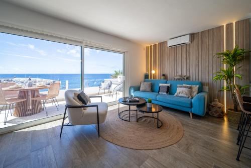 a living room with a blue couch and a view of the ocean at Casa Galana in Tías