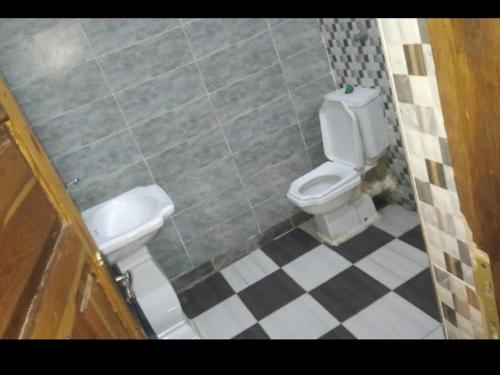 a bathroom with a toilet and a tiled floor at Labib Guest House in Aswan