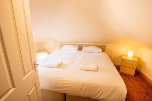 a bedroom with a bed with white sheets and pillows at Traquair Arms Hotel in Innerleithen