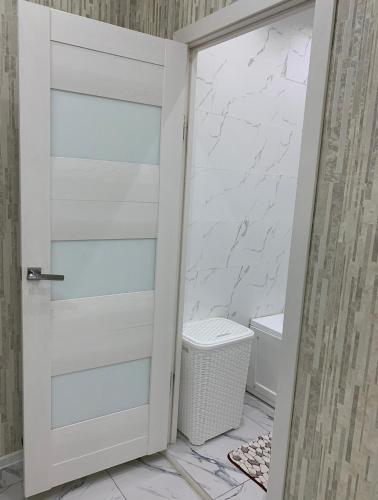 eine weiße Tür im Bad mit WC in der Unterkunft Кылышбай акына in Taras