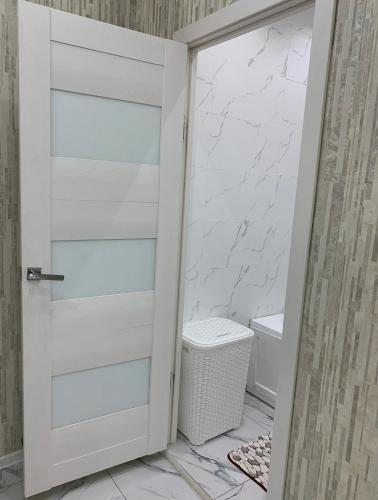 eine weiße Tür im Bad mit WC in der Unterkunft Кылышбай акына in Taras