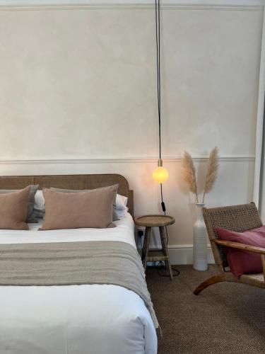 a bedroom with a bed and a chair and a lamp at Coed Mawr Hall Bed & Breakfast in Conwy
