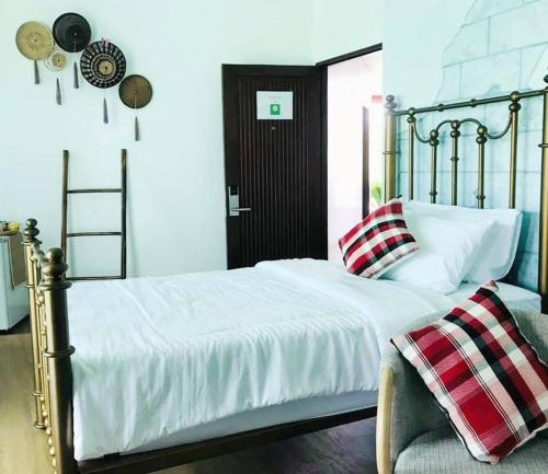 a bedroom with a bed with white sheets and a ladder at Pupah Kanna Pua-ปู๋ ป๋าล์ คันนา ปัว in Pua
