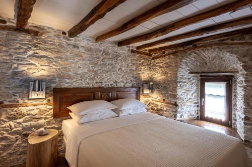 a bedroom with a bed in a stone wall at Mountain's Secret in Mouresi