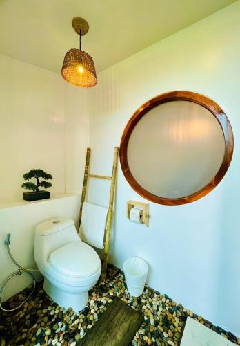 a bathroom with a toilet and a large mirror at Pupah Kanna Pua-ปู๋ ป๋าล์ คันนา ปัว in Pua