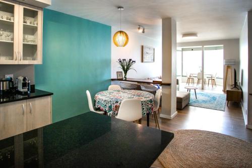 kuchnia i salon ze stołem i krzesłami w obiekcie Bayview 208 w mieście Hermanus