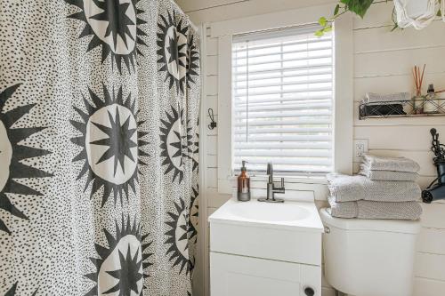 a bathroom with a black and white patterned shower curtain at Downtown Tiny Home near Shenandoah National Park in New Market