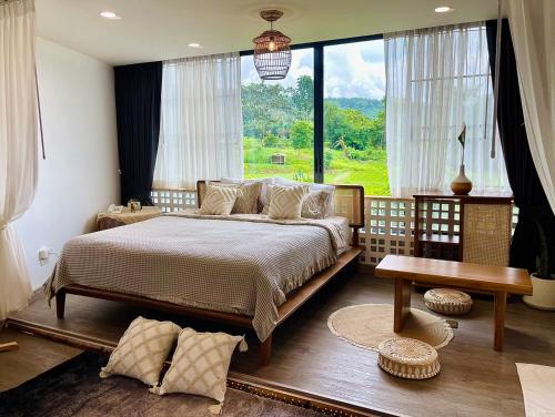 a bedroom with a large bed and a large window at Pupah Kanna Pua-ปู๋ ป๋าล์ คันนา ปัว in Pua