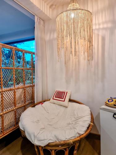 a room with a bed with a chandelier and a window at Pupah Kanna Pua-ปู๋ ป๋าล์ คันนา ปัว in Pua