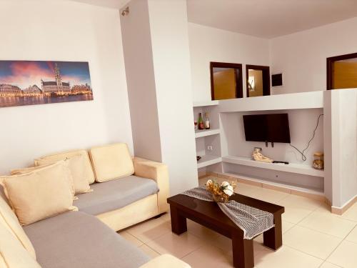 a living room with a couch and a tv at Villa Merkuri in Himare