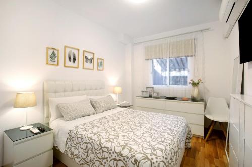 a white bedroom with a bed and a window at Apartamento Playa in Puertito de Güímar