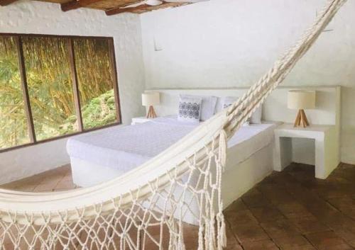 1 dormitorio con 1 hamaca en una habitación con ventanas en Casa Kalica, en Camacorinto