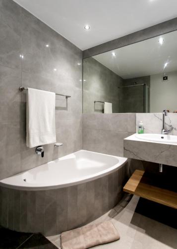 a bathroom with a large tub and a sink at Bayview 208 in Hermanus