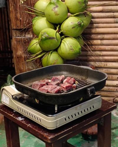 a pan of meat on a grill on a table at Tiki Bar-KanTiang Guesthouse in Ko Lanta