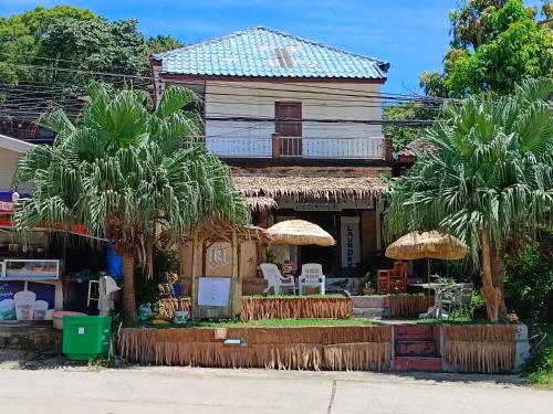 een huis met palmbomen ervoor bij Tiki Bar-KanTiang Guesthouse in Koh Lanta