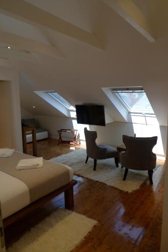 a bedroom with a bed and two chairs and a piano at San Teodoro in Korčula