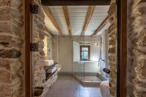 a bathroom with two sinks and a glass shower at Mountain's Secret in Mouresi