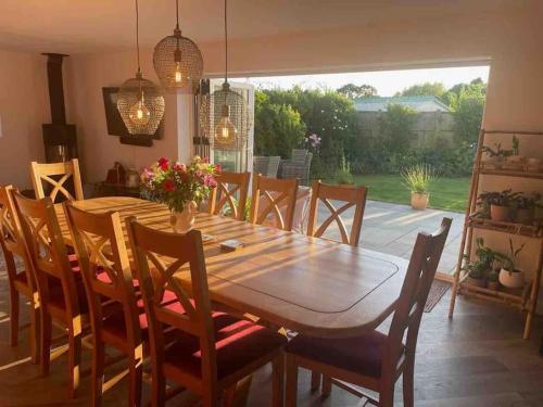 a dining room with a wooden table and chairs at The Sails in East Wittering