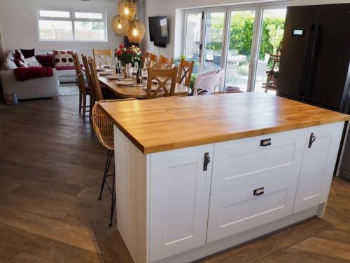 a kitchen with a kitchen island with a wooden counter top at The Sails in East Wittering