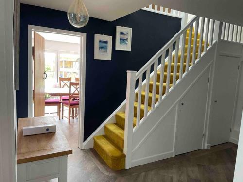 a staircase in a living room with a yellow stair case at The Sails in East Wittering