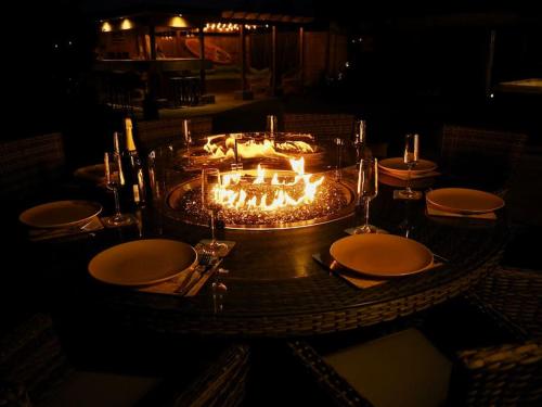 a table with plates and candles on top of it at The Sails in East Wittering