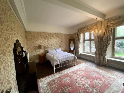 a bedroom with a bed and a large window at Thornhaugh Old Rectory in Peterborough