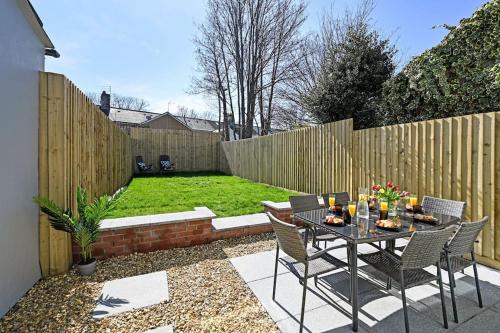 a backyard with a table and chairs and a fence at Luxury Central City Centre Townhouse with Garden in Cardiff