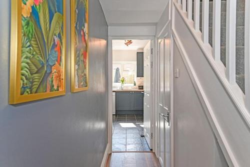 a hallway with a staircase with a painting on the wall at Luxury Central City Centre Townhouse with Garden in Cardiff