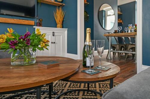 a dining room table with a bottle of champagne and flowers at Luxury Central City Centre Townhouse with Garden in Cardiff
