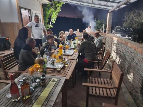 eine Gruppe von Menschen, die an einem langen Tisch sitzen in der Unterkunft Big Bear Hunting Lodge in Buzău