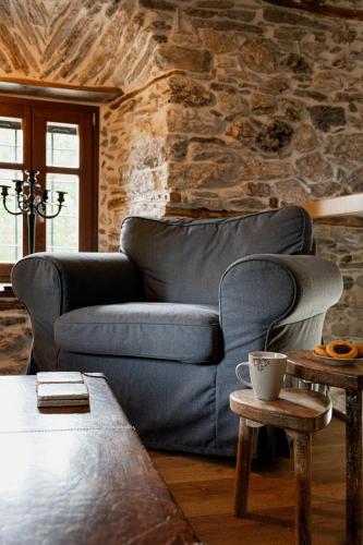 a couch in a living room with a stone wall at Mountain's Secret in Mouresi